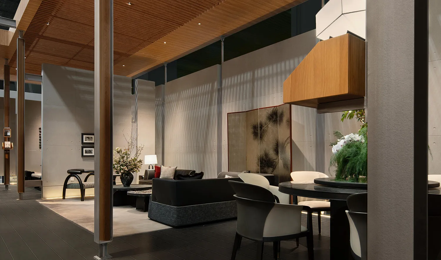Modern hotel lobby lounge featuring dark wood furniture, a round black dining table with cream chairs, a black sofa, wooden ceiling panels, and a traditional Chinese pine tree folding screen.
