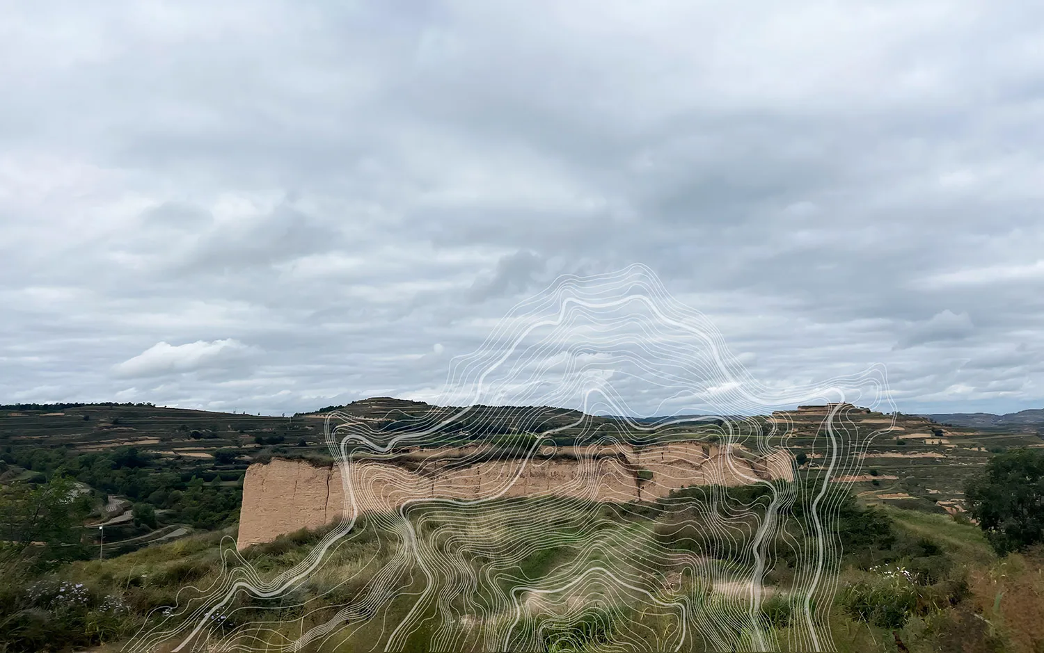 Wide landscape view of the Loess Plateau in China featuring eroded earthen hills, green vegetation, and a large white abstract topographic wave graphic overlay under a cloudy sky.