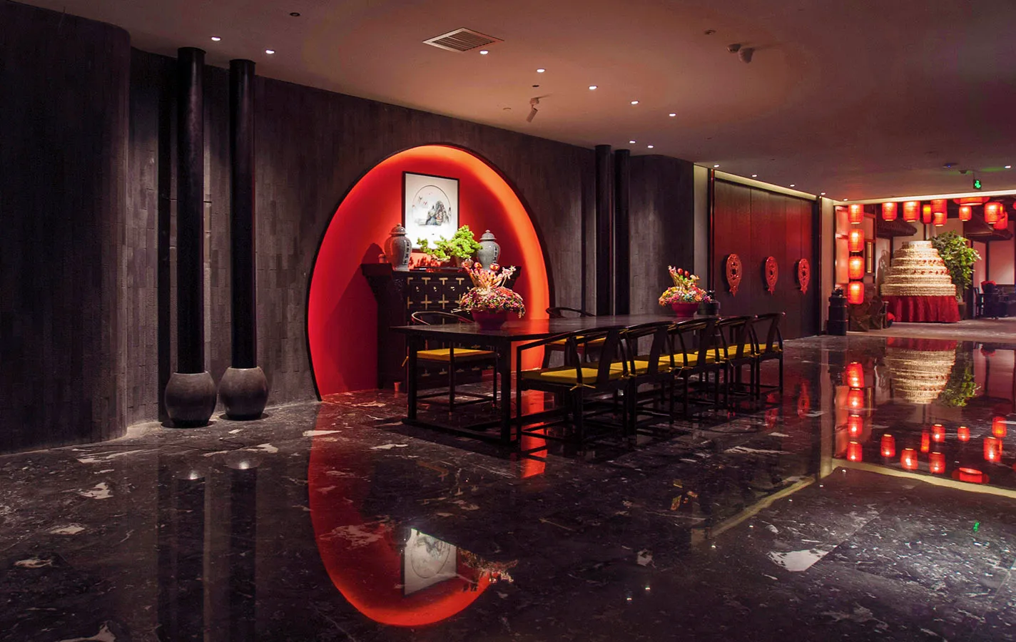 奢華中式餐廳內部,特色為發光的紅色圓拱、黑色大理石反光地板、深色木質牆面,以及搭配黃色絲綢椅子的傳統黑色餐桌。
