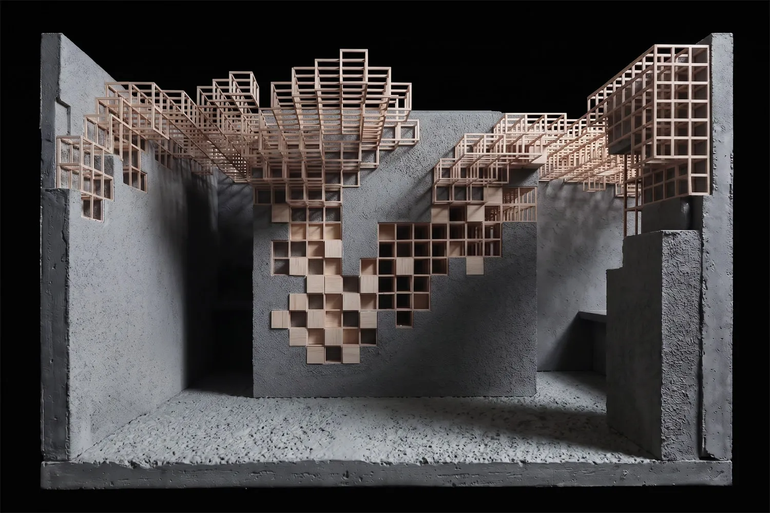 Architectural scale model of a modern library interior featuring grey concrete walls and an intricate system of light-colored wooden bookshelves arranged in a pixelated, cascading pattern across multiple levels.