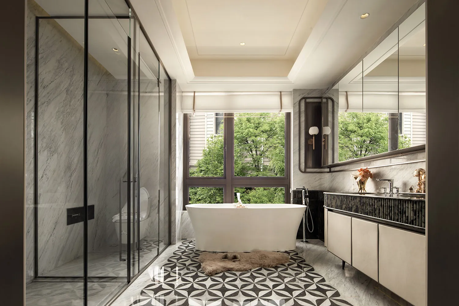 Modern luxury bathroom interior with white freestanding bathtub, marble walls, black and white geometric patterned floor tiles, and large windows overlooking green trees.