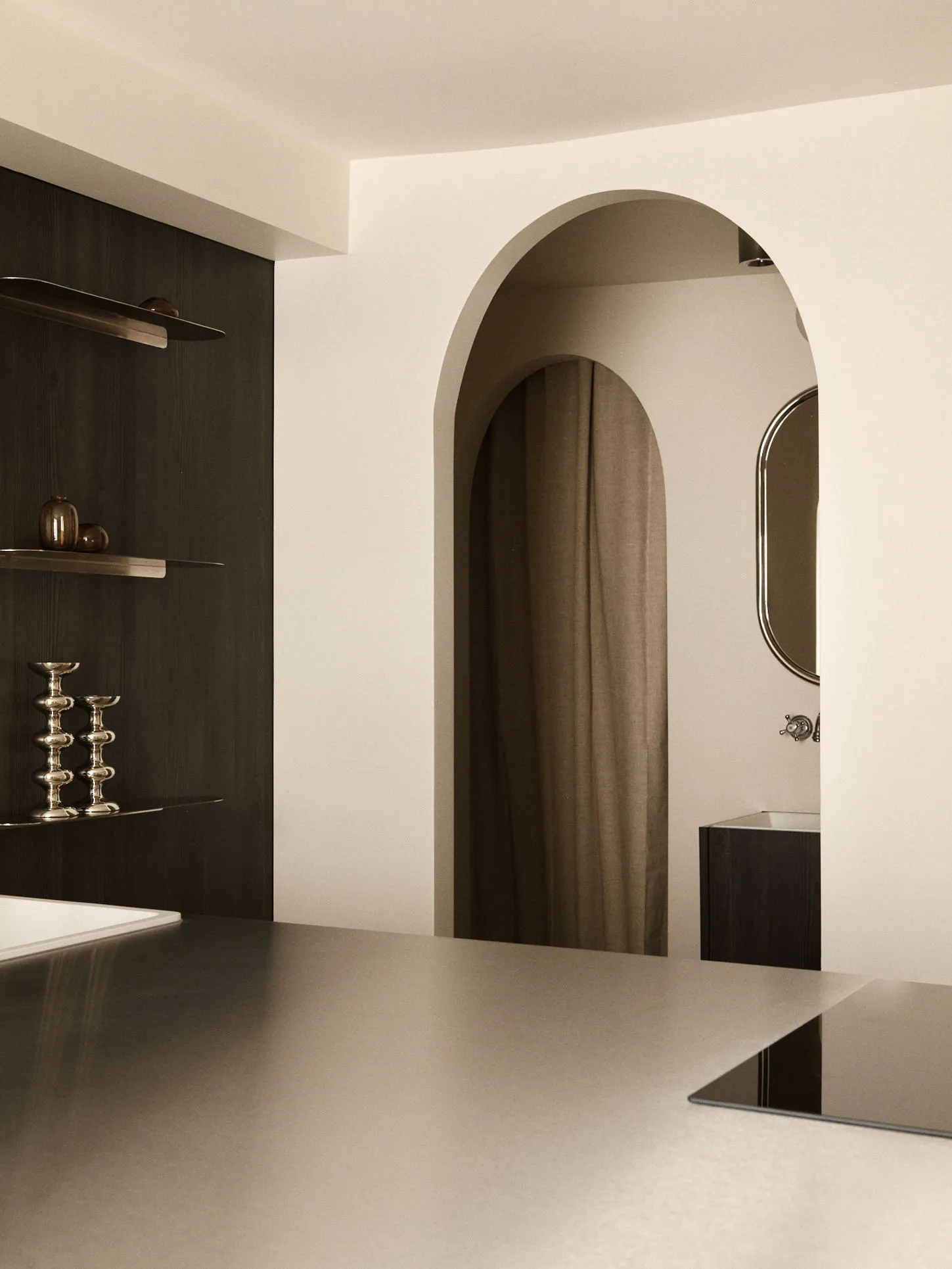 Modern minimalist interior featuring dramatic arched passageways, dark wood built-in cabinetry with floating shelves, metallic decorative objects, and a neutral color palette.