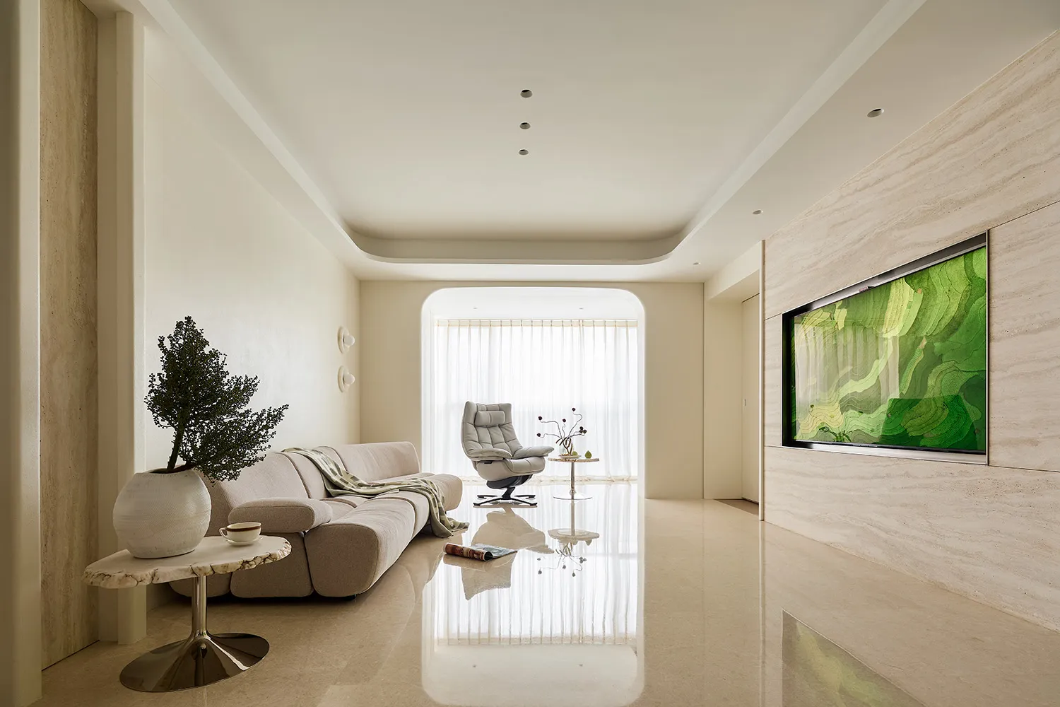 Modern minimalist living room featuring travertine marble walls, a cream modular sofa, a white recliner, and a large green abstract landscape artwork on the right wall.