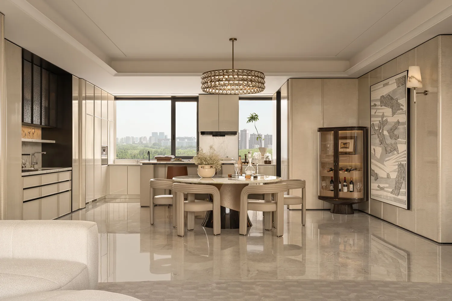 Modern luxury dining room with round Calacatta marble table, beige upholstered chairs, crystal chandelier, and open kitchen in neutral tones