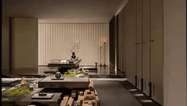 Modern Japanese zen living room featuring a large walnut wood platform, tatami-style sunken seating, vertical wood slat wall, and minimalist stone and moss arrangements.