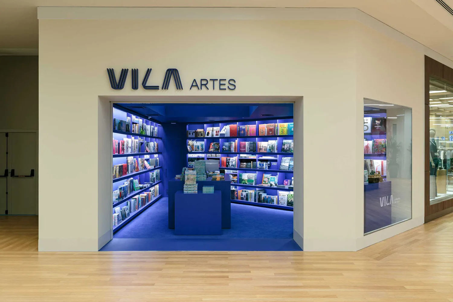 Vila Artes書店入口，可見藍色LED照明的書架、藍色地毯與中央藍色展示島。