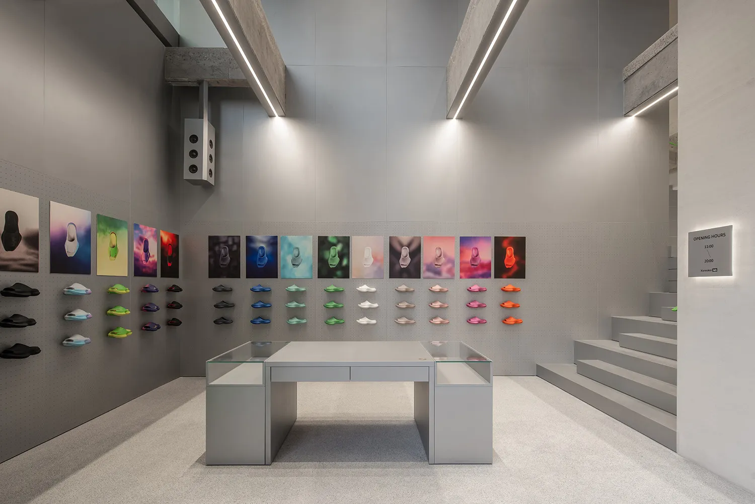 現代極簡球鞋零售店內部,原始混凝土牆面、線性LED燈光、玻璃展示桌,以及以網格方式排列的彩色球鞋牆面展示。