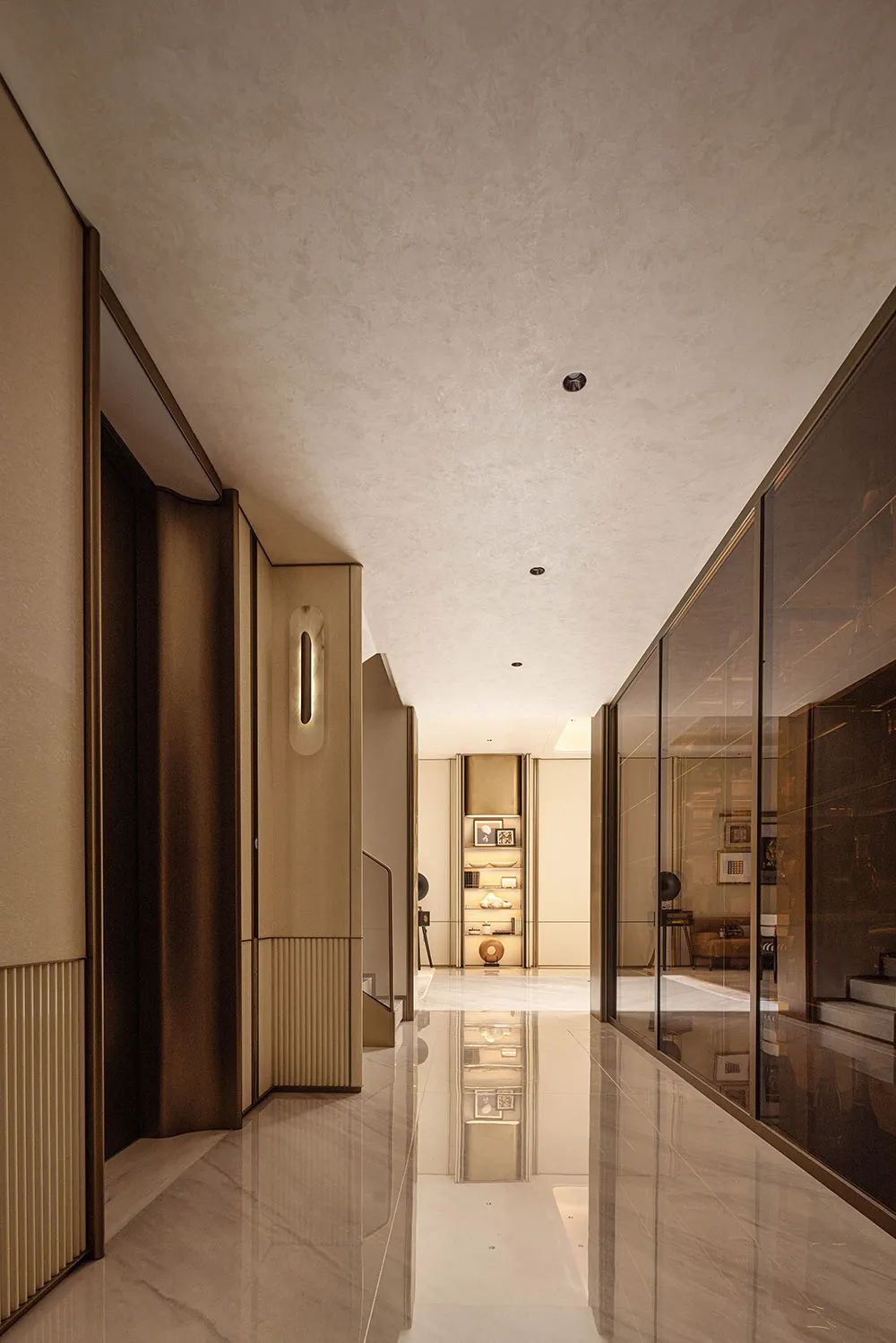 Long modern luxury hallway with white marble floor, bronze-toned wall panels, vertical light fixtures, and glass display walls reflecting the space.