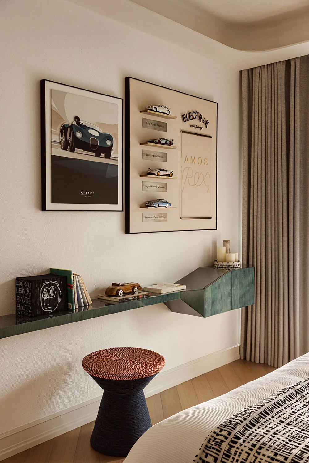 Modern bedroom corner with a teal floating console shelf displaying books and model cars, a woven stool, framed automotive art, and a curated car collection display on the wall.