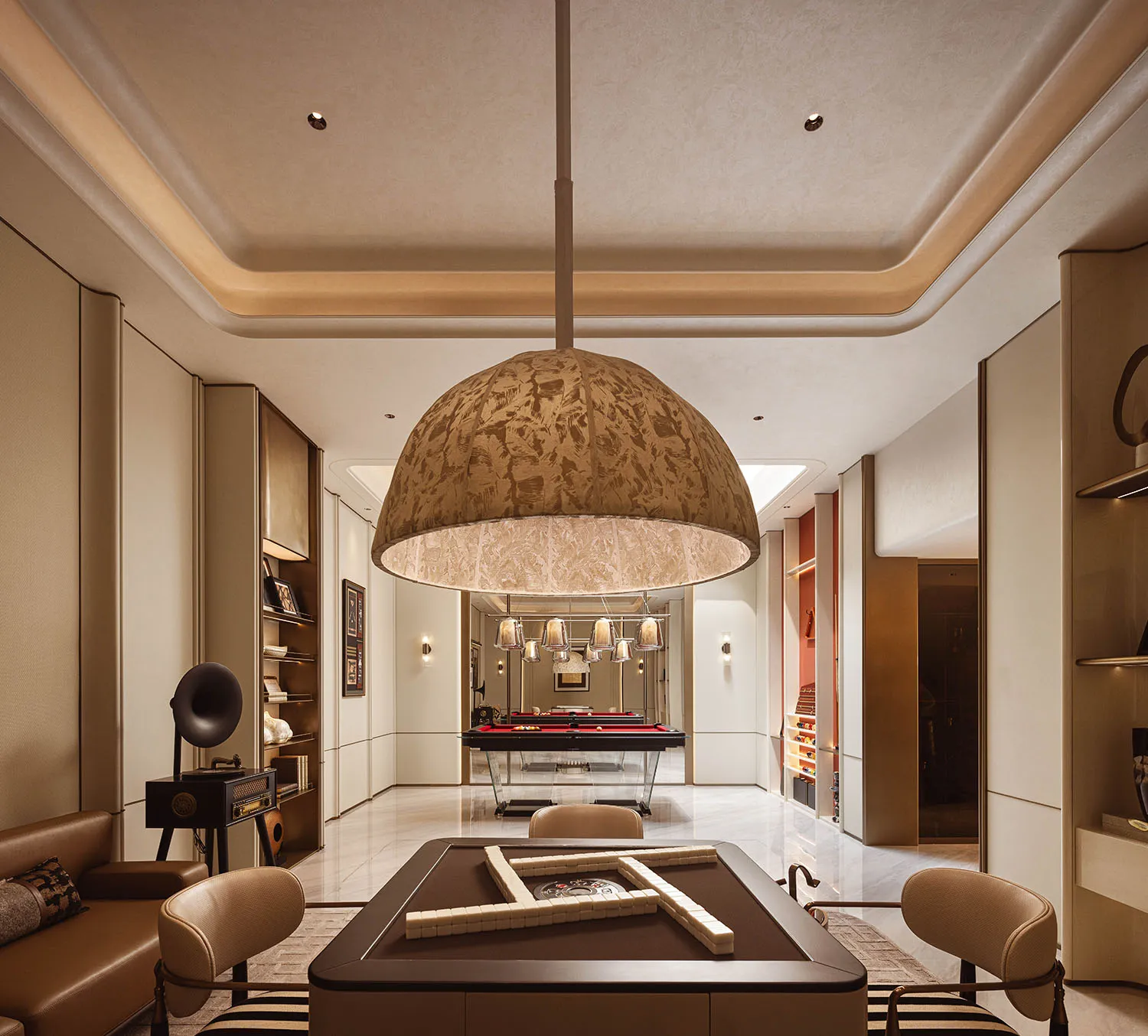 Luxurious modern game room with a large patterned fabric pendant light, walnut mahjong table set with tiles, leather sofa, and a pool table visible in the background.