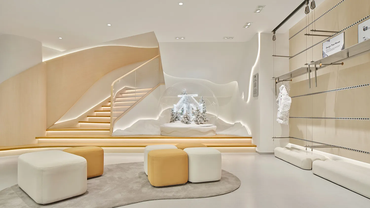 Modern minimalist retail interior with a large illuminated snow globe display, curved oak staircase with integrated lighting, and modular white and mustard ottomans on a grey rug.