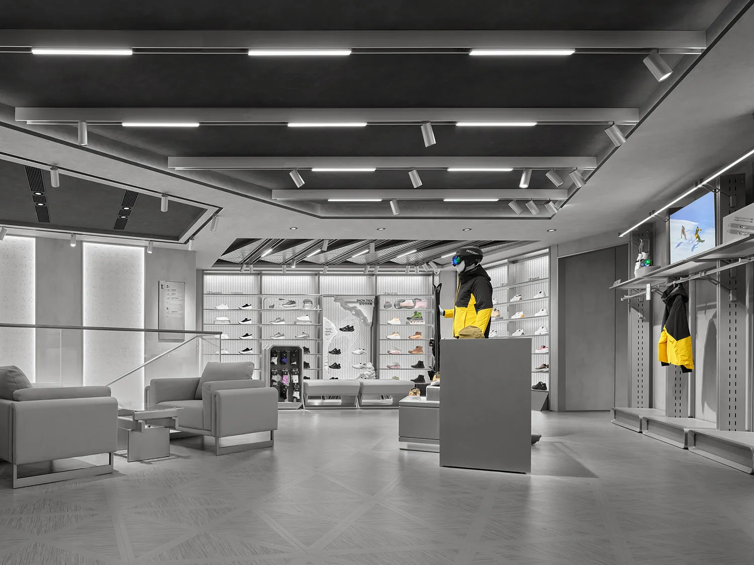 Modern minimalist ski and snowboard retail store interior featuring concrete walls, geometric floor tiles, linear LED lighting, grey lounge seating, and a mannequin wearing a bright yellow and black ski jacket.