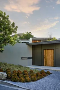 Modern residential entrance with concrete walls and wooden door.