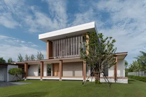 A modern residential home with a concrete facade and wooden elements.