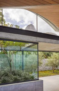 Modern home interior featuring glass walls, concrete base, and stone accents.