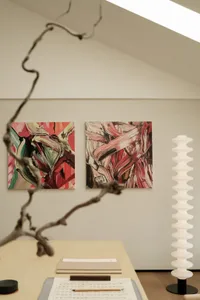 A modern interior space featuring abstract art with red, pink, and black colors.