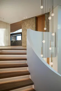 Modern interior design featuring a wooden staircase with integrated lighting.