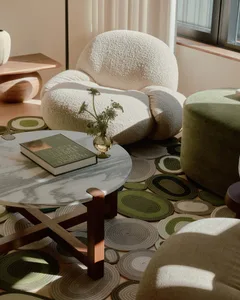 A modern living room featuring a plush, textured couch and various textured textiles on the floor.