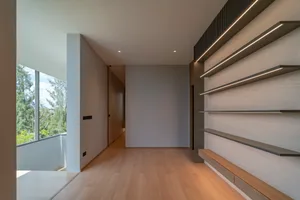 A minimalist interior with wooden shelves and a view of the outdoors.