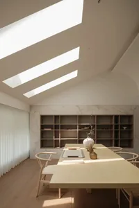 Contemporary study with wooden table, marble accent wall, and skylights