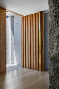 A wooden folding door with metallic accents in a modern interior setting.