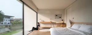 Modern minimalist bedroom with glass wall, wooden floor, and white furniture.