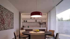 Modern dining room interior with minimalist design, featuring concrete materials and a centrally placed round table.