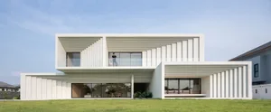 A modern residential house featuring concrete and glass exterior.