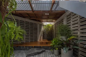 Modern industrial living room with concrete walls and urban greenery.