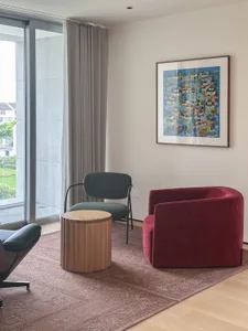 A modern living room featuring upholstered furniture and wooden elements.