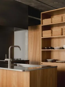 A modern kitchen with wooden cabinets and a stainless steel sink.