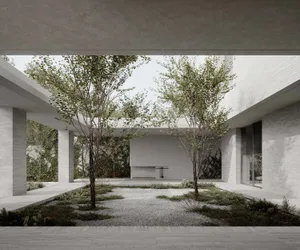 Concrete garden with trees and gravel pathway.