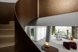 A modern living room featuring a metallic staircase with curved steps.