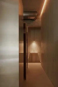 現代極簡浴室，混凝土牆面與地板，搭配流線型洗手台與燈光設計。