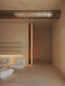 Modern minimalist interior space with concrete flooring and minimalist furniture.