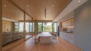 Minimalist modern kitchen dining and living room with wood and metallic accents.
