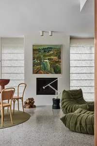 Modern minimalist living room featuring concrete materials and large windows with white fabric blinds.