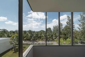 Large glass window overlooking a serene landscape with trees and sky.
