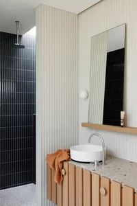A minimalist bathroom with a terrazzo countertop and sink.