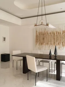 A minimalist dining room featuring a wooden table and chairs.