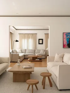 A well-designed, minimalist modern living room with neutral tones and stylish furniture.