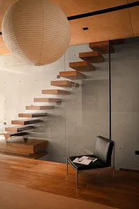Modern interior featuring a wooden staircase against a concrete wall.