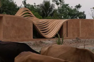 A modern architectural design featuring a wave-like structure made of concrete.