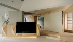 A modern living room featuring light-colored wood furniture, minimalist design, and natural light.