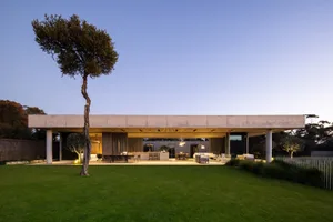 A modern living space with a concrete structure and glass elements.