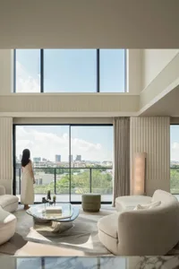 A modern residential living room featuring a view through large windows with a minimalist design.