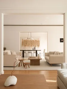 Neutral-toned living room with contemporary design elements, including a minimalist sofa, wooden coffee table, and abstract a