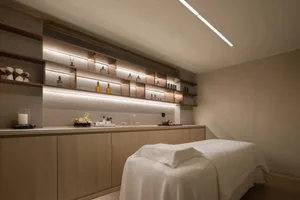 A serene spa treatment room featuring neutral-toned walls and modern fixtures, creating a calm and relaxing atmosphere.