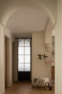 A minimalist living room featuring a wooden floor and white walls.