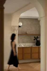 A minimalist residential space featuring wood and marble accents with warm, ambient lighting.
